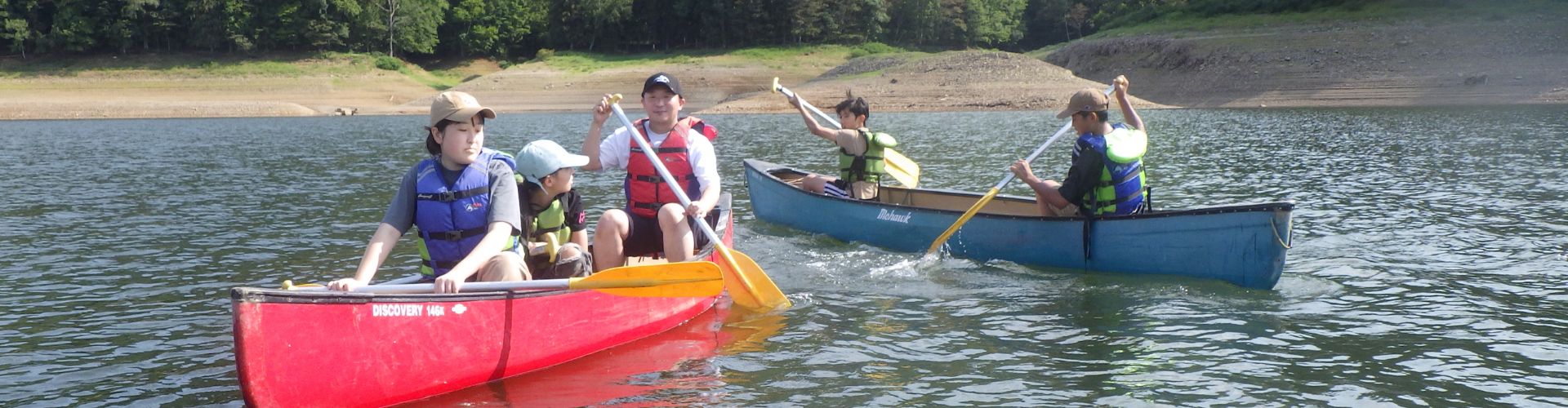 A Canadian canoe gliding on a tranquil lake.
