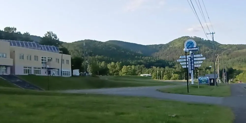The meeting point at the Kanayama Lake Recreation Center, with the building and surrounding green landscape.