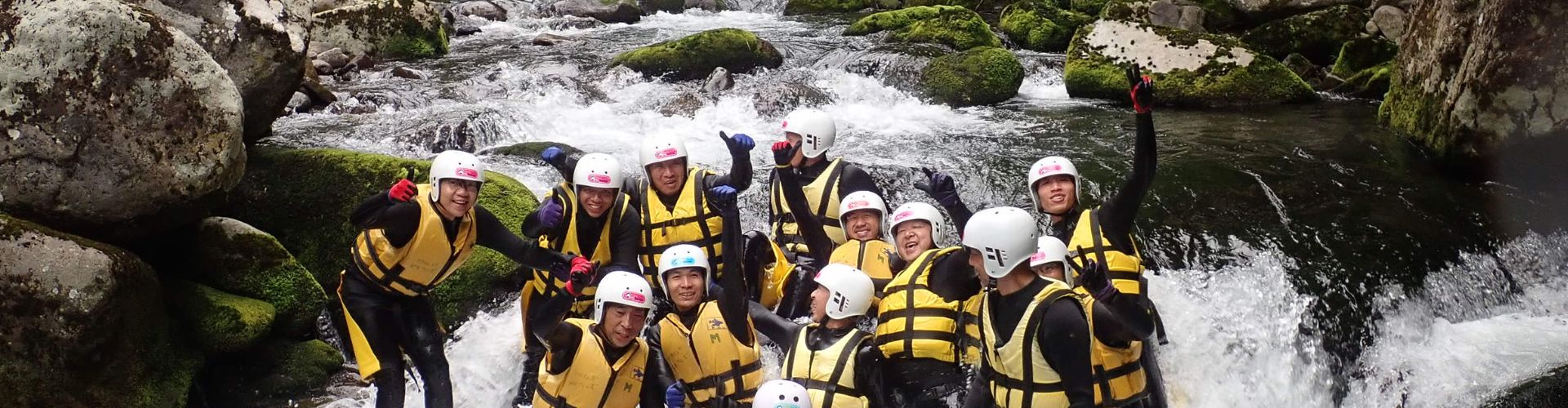 A person sliding down a natural water slide during a canyoning tour.