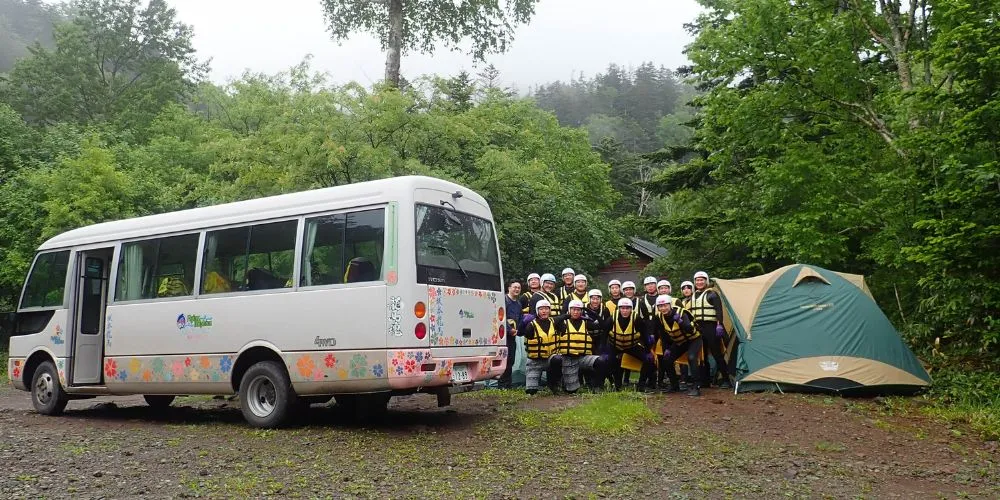 The tour group gathered at the base camp with the bus and changing tent, ready for the Wild Canyoning adventure.