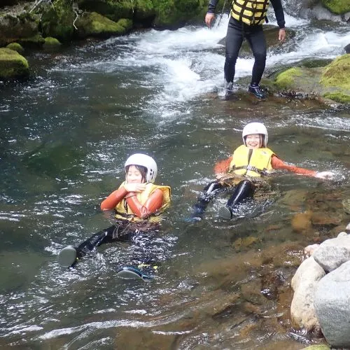 Two participants enjoying a moment of calm, floating peacefully in the clear water of the canyon.