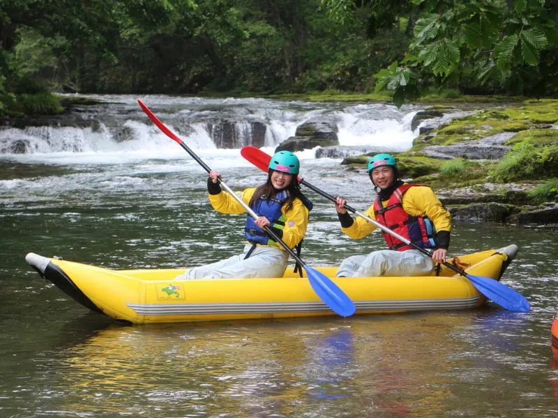 A pair of adventurers navigating their own ducky through exciting whitewater, with a guide nearby.