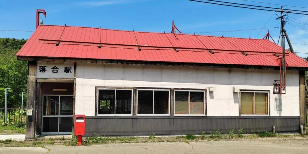 The meeting point at the historic Former Ochiai Station building with its distinct red roof.