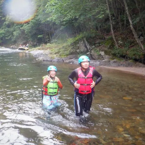 A group of ducky participants resting on a rocky riverbank, enjoying the view.