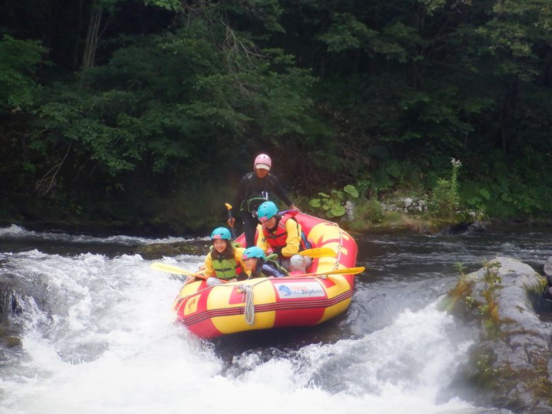 A family navigating a gentle rapid together, creating exciting and lasting memories on their rafting adventure.