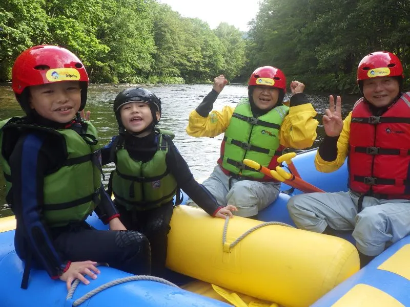 A family with young children enjoying a safe and gentle rafting experience on a calm river.