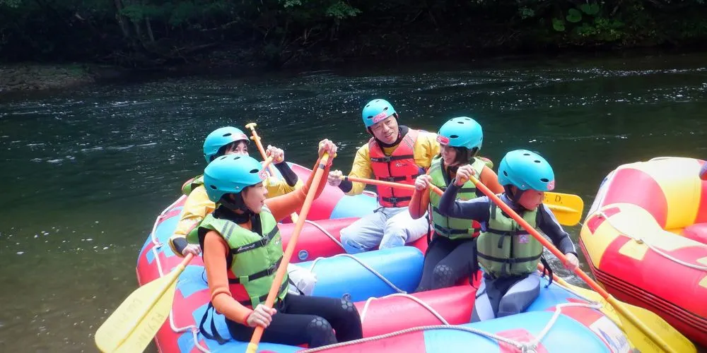 A guide demonstrating how to hold and use a paddle to a group of participants during the safety briefing.