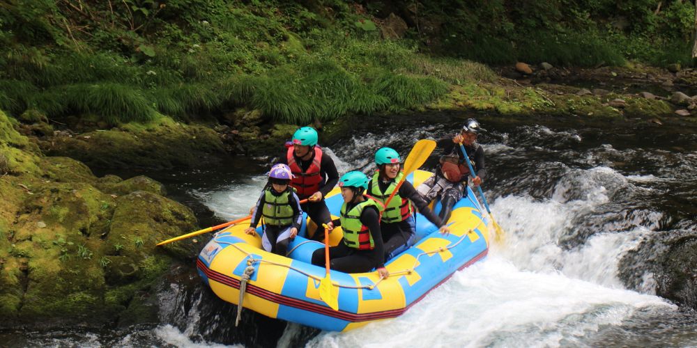 A family experiencing the thrill of a gentle rapid, guided safely through the whitewater.