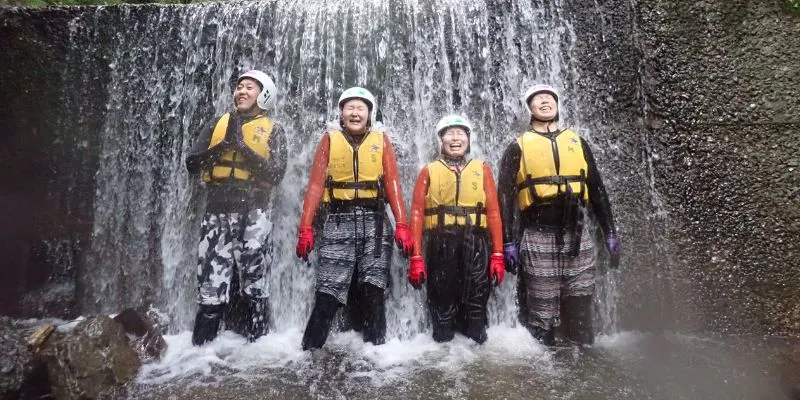A person jumping into a waterfall during a canyoning tour.