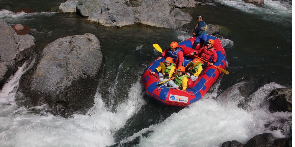 An action shot of a rafting boat descending a steep, powerful rapid on the Mukawa River, showcasing the tour's thrilling nature.