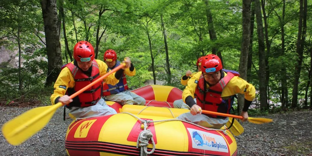 A team of rafters practicing their paddling strokes in the raft before heading out onto the main river.