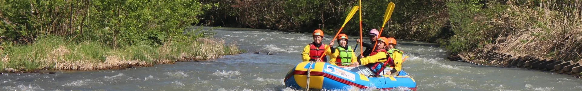 A family enjoying a scenic rafting trip on the Chubetsu River, surrounded by the beautiful nature of Daisetsuzan National Park.