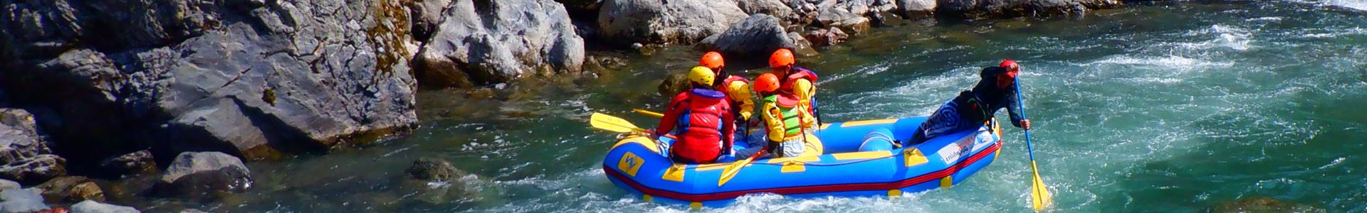 A team of rafters skillfully navigating the challenging, rocky gorges of the Mukawa River on a thrilling rafting tour.