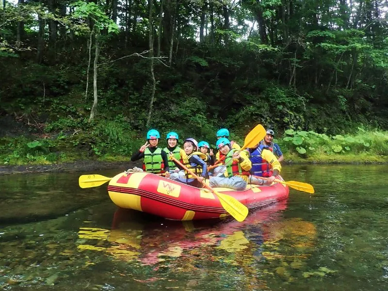 A family with children enjoying a safe and fun rafting experience on a gentle part of the river.