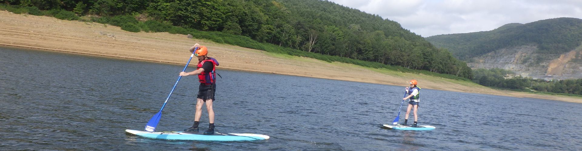 People enjoying Stand Up Paddleboarding on a calm lake.