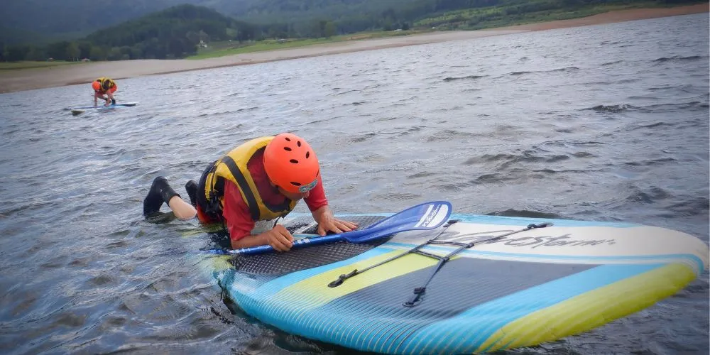A participant practicing paddling while lying on their stomach, a fun way to enjoy the SUP board.
