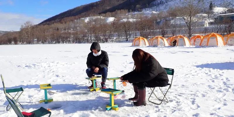 A friendly guide teaching a child how to fish.