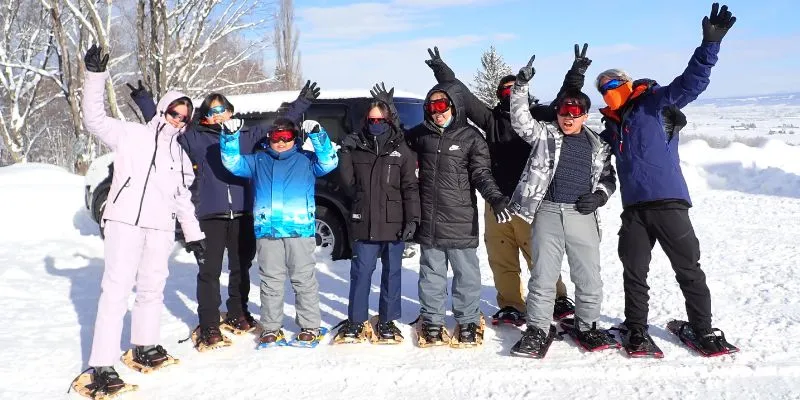 A person snowshoeing in a deep snowy forest.